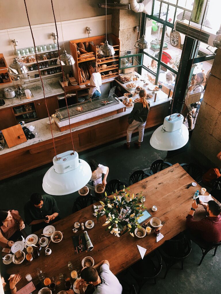 A vibrant aerial view of a busy cafe in Kraków, showcasing patrons enjoying baked goods and coffee.