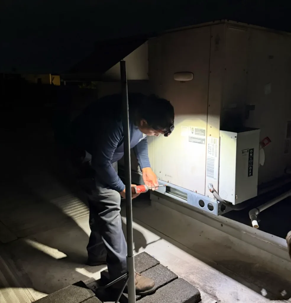Eco-One technician working at an HVAC air handler in an attic