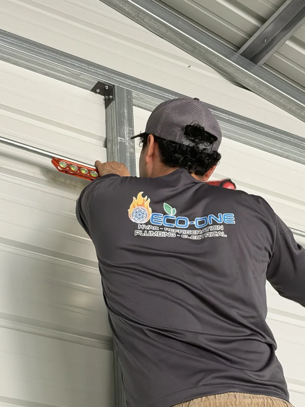 Eco-One electrical technician measuring conduit work inside a metal building