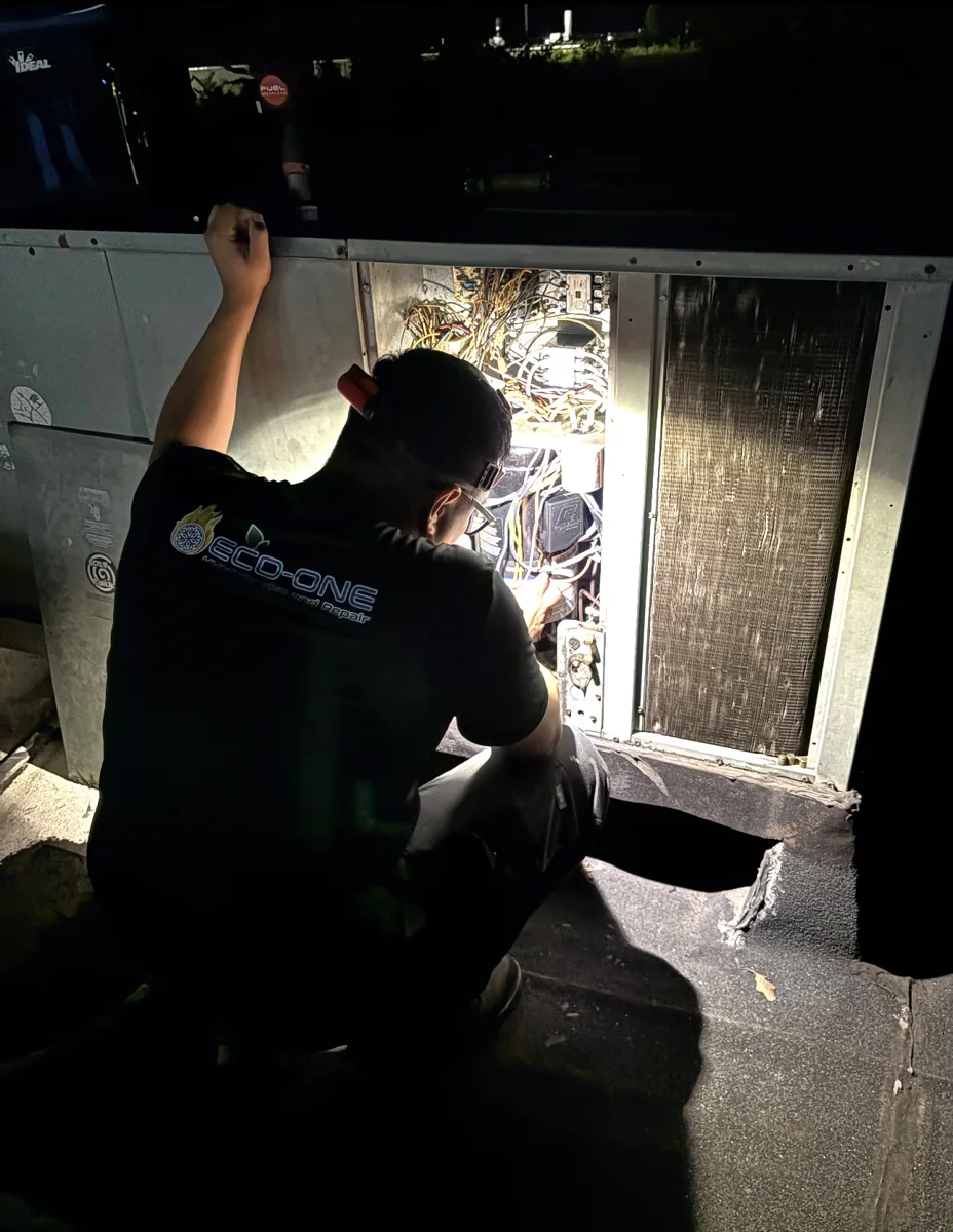 Eco-One technician inspecting the electrical components inside HVAC equipment