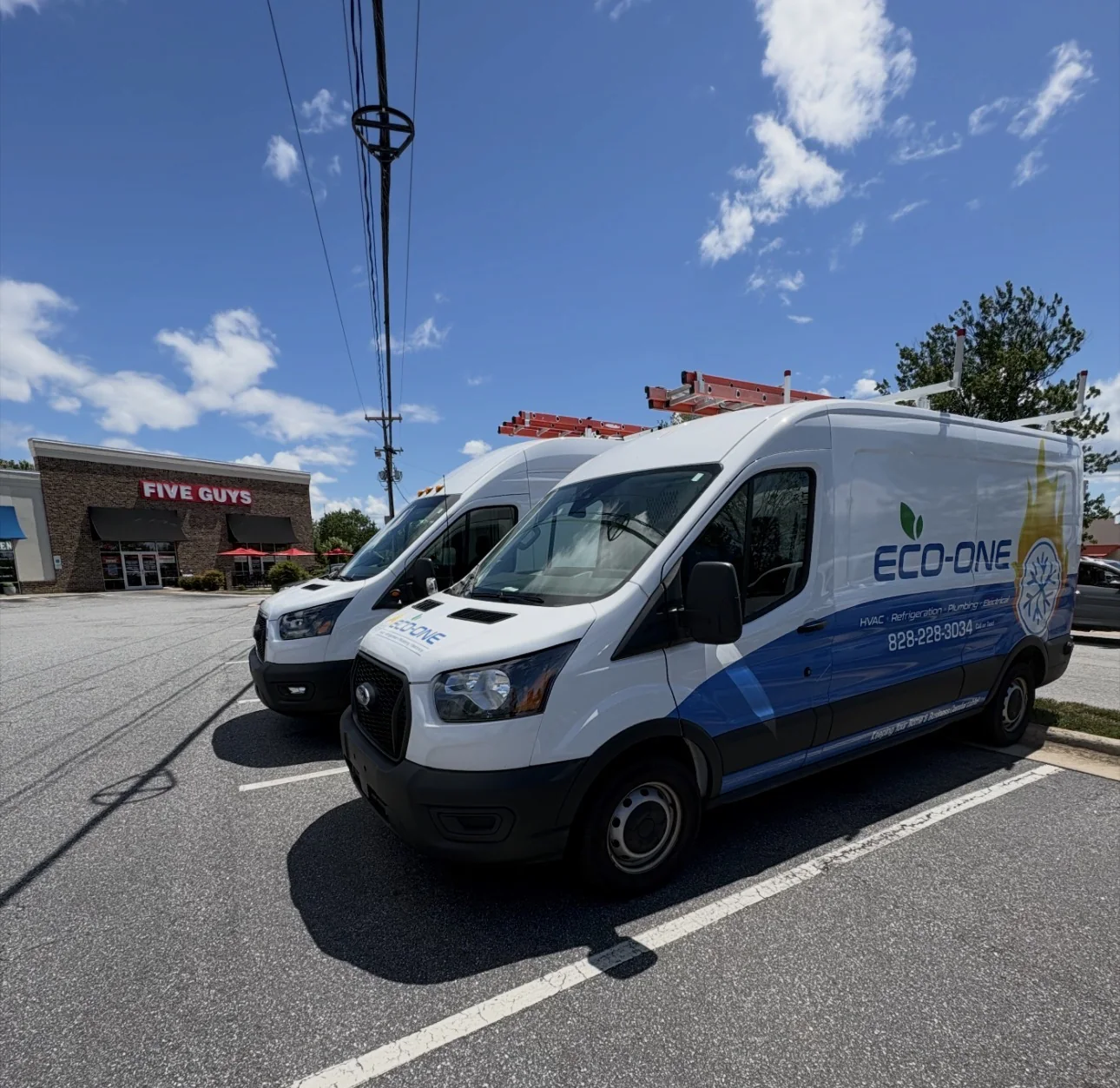 Two Eco-One service vans parked together on a clear day